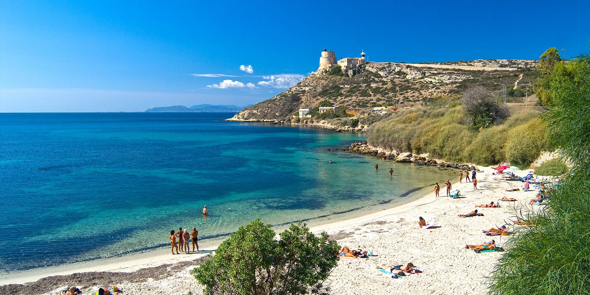 Cala Mosca, Cagliari: piccola spiaggia ai piedi della Torre di Sant'Elia con sabbia bianca e acqua trasparente, nascosta tra il porto e il Poetto.