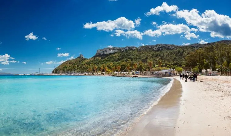Il Poetto, Cagliari: otto chilometri di spiaggia con sabbia chiara e mare turchese ai piedi della Sella del Diavolo, lungomare con palme e chiringuiti.