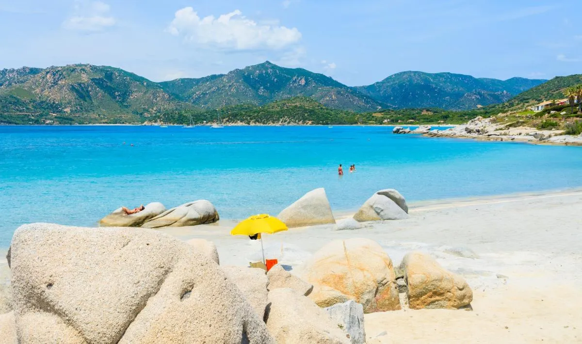Spiaggia del Riso a Villasimius, Sardegna: spiaggia unica con caratteristici chicchi di quarzo bianco simili a granelli di riso, acqua trasparente.