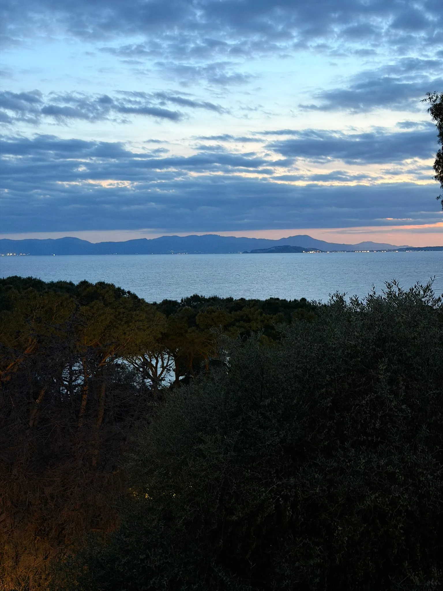 Tramonto arancione sul Golfo di Cagliari con profilo di Marina Piccola in lontananza.